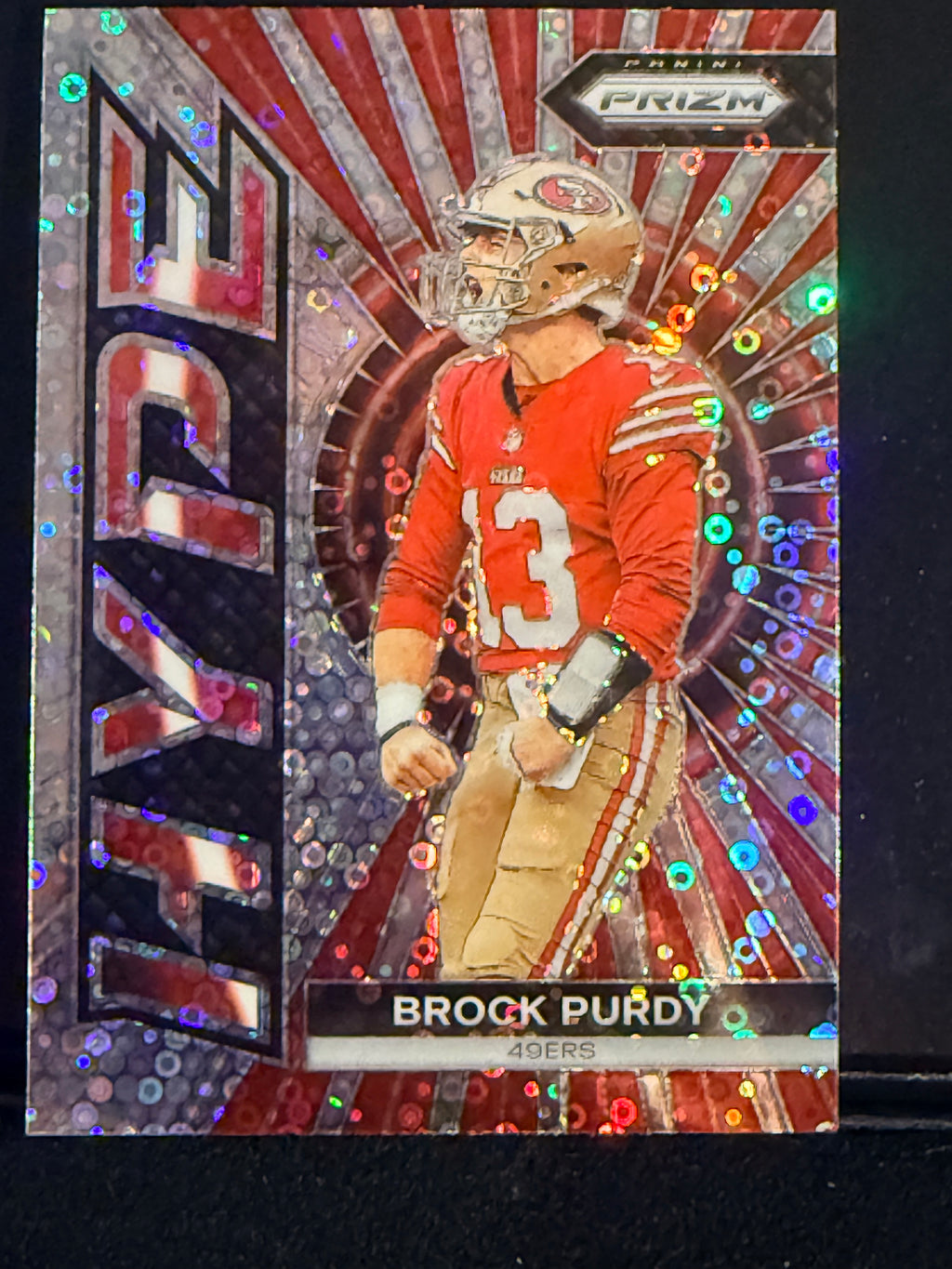 A collectible 2023 HYPE Brock Purdy San Francisco 49ers trading card, featuring a holographic silver and red design with a photo of the football player in his red jersey.